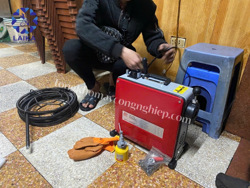 Thợ thông tắc sử dụng máy thông cống lò xo xử lý tắc nghẽn Thợ thông tắc sử dụng máy thông cống lò xo xử lý tắc nghẽn